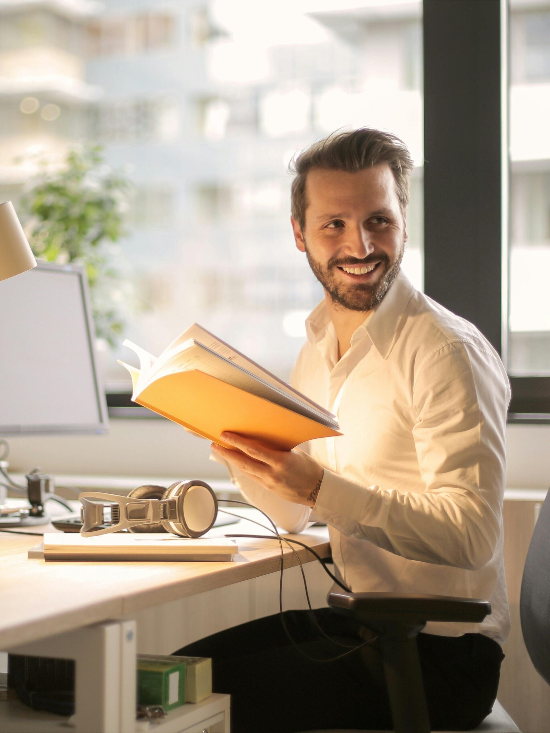 A relaxed businessman enjoying a break in his bright, contemporary office environment.